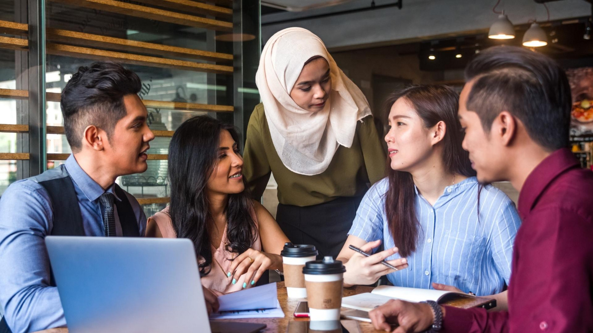 A group of 3 women and 1 man having a discussion